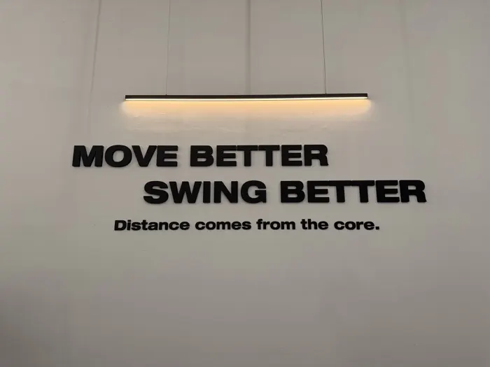 MOVE BETTER SWING BETTER 문구가 붙은 스튜디오 벽